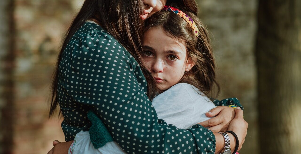 Macy gets a big hug from a mission worker from Latin America
