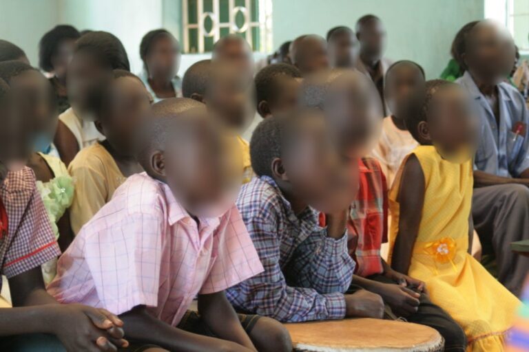 Children listening during a teaching time in Africa (faces blurred)