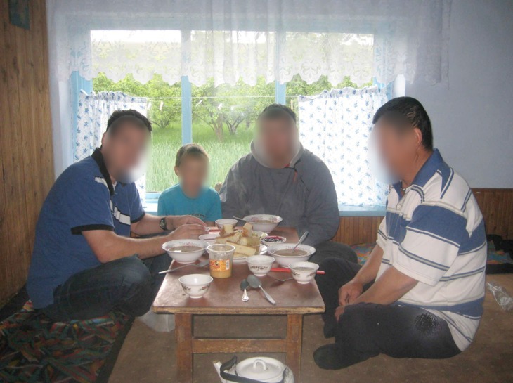 Sharing a meal with a host family in Central Asia (faces blurred)